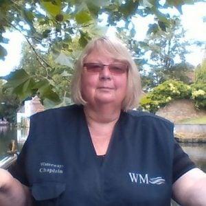 A head and shoulders picture of Lorraine Newman in Waterways Chaplaincy uniform, standing on the stern of her boat.