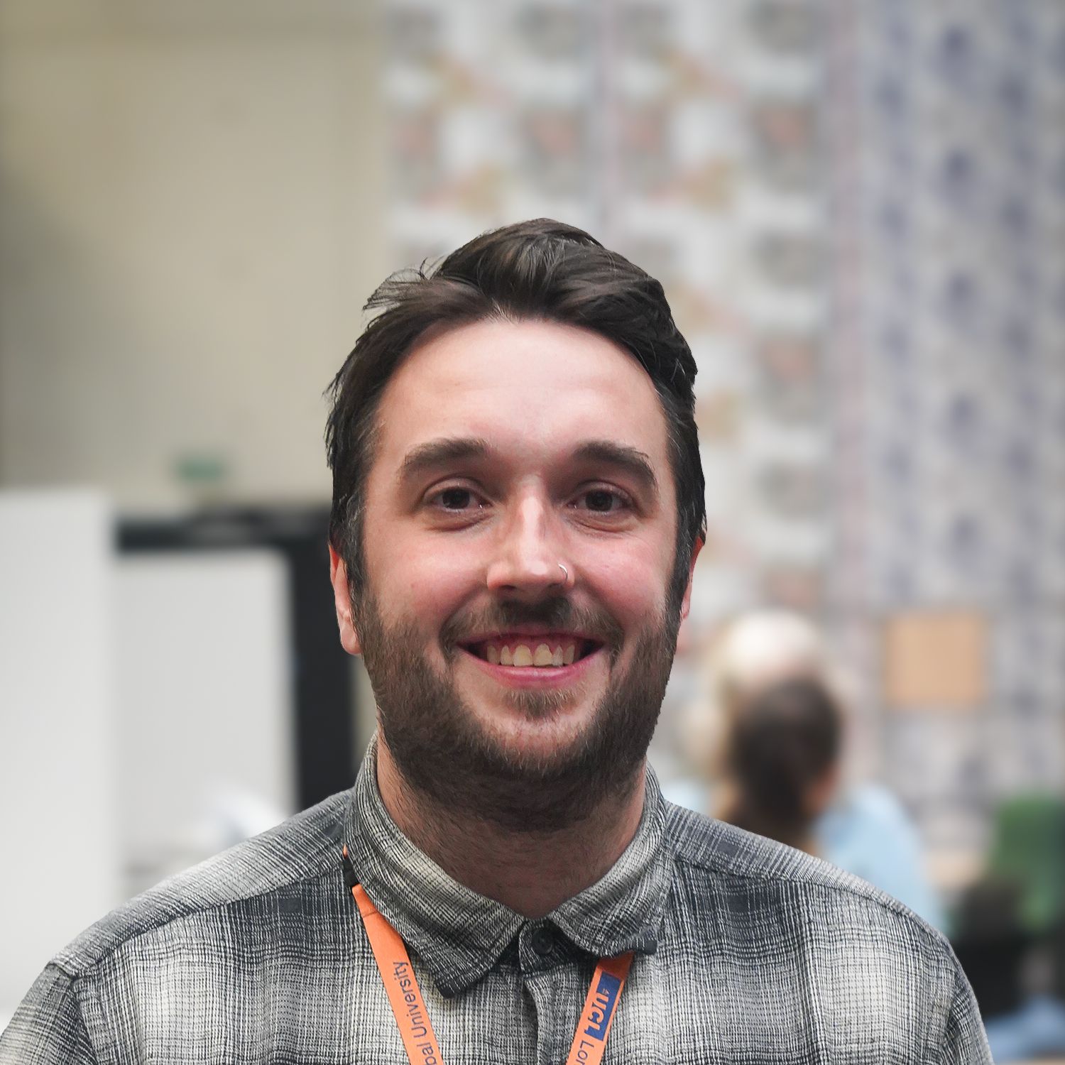 Joseph Cook - a young man with dark hair and beard, wearing a light brown check shirt.